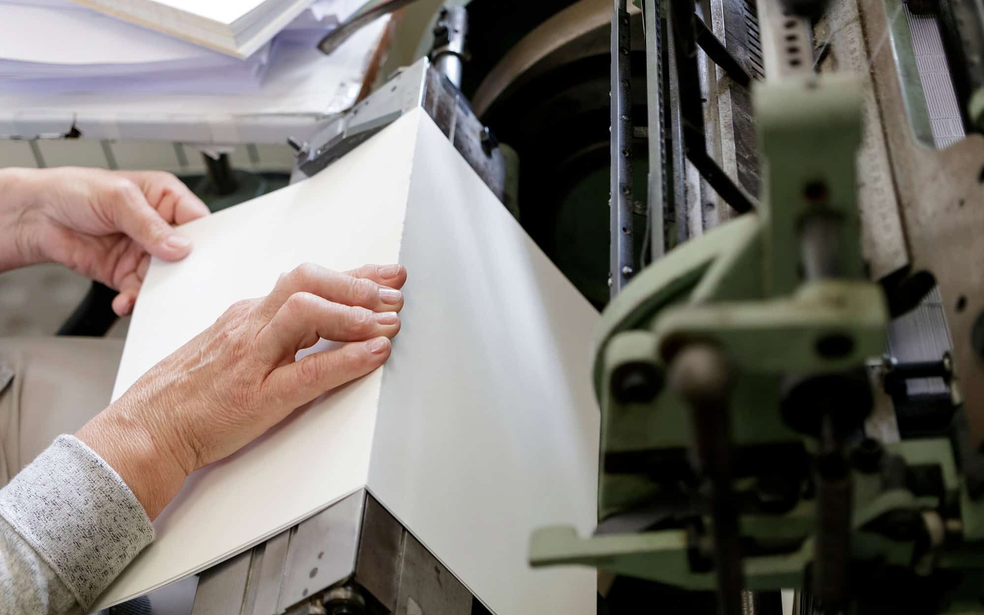 Man Inserting Carton Into The Cart Paper Folding Machine