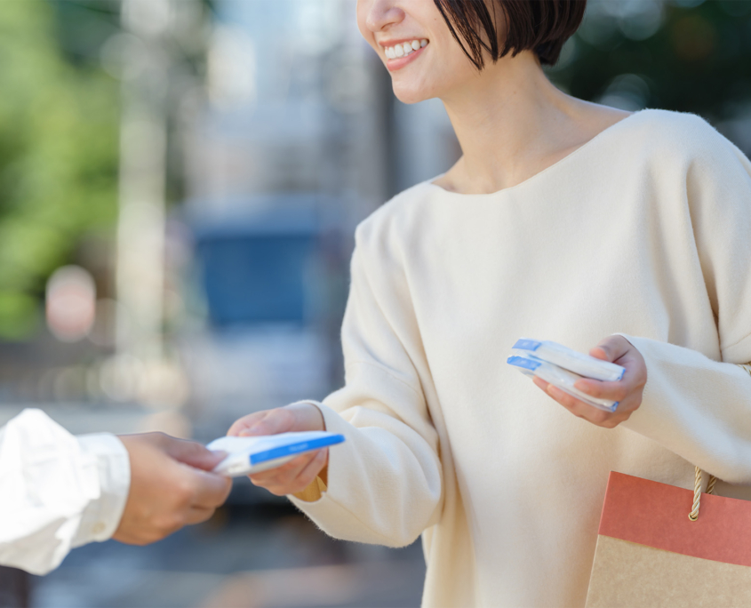 Side View Of Young Woman Handing Out Promotional Items